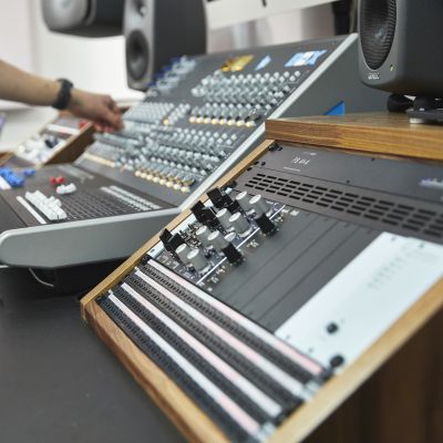 Electronic music student at a mixing desk in a studio